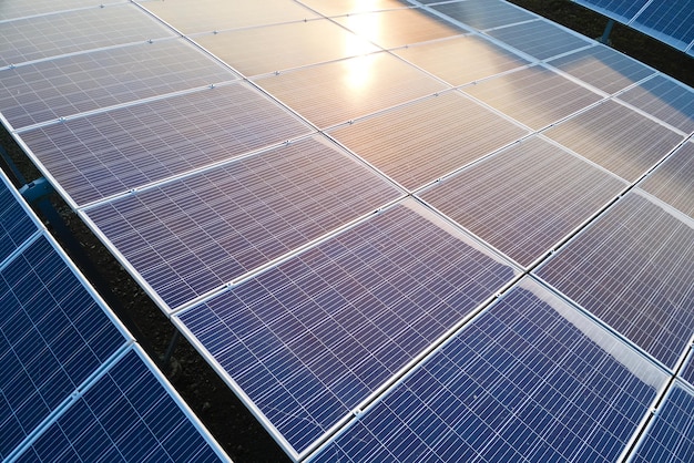 Aerial view building roof with rows of blue solar photovoltaic panels for producing clean ecological electric energy. Renewable electricity with zero emission concept.