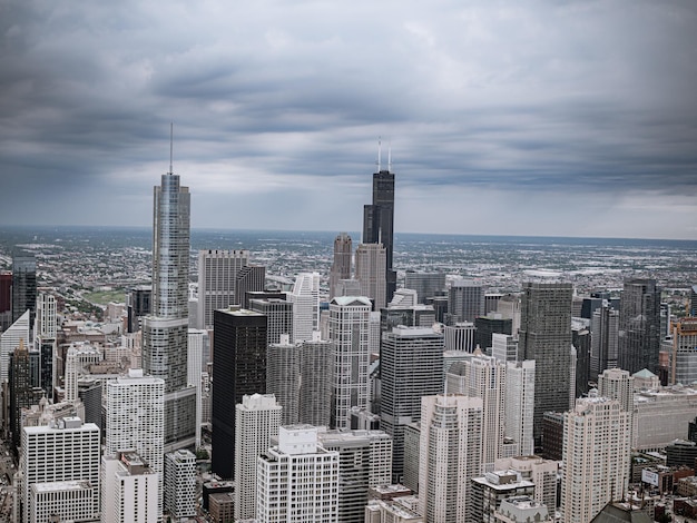 Photo aerial view of buildings in city against cloudy sky