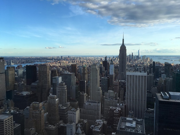 Aerial view of buildings in city against cloudy sky