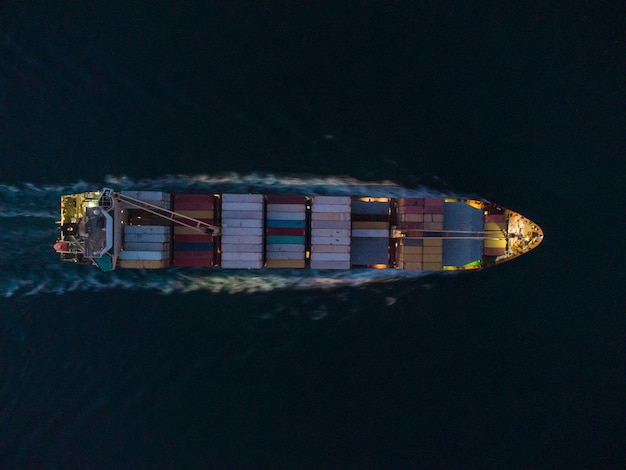 Aerial view of cargo container ship in the sea at night