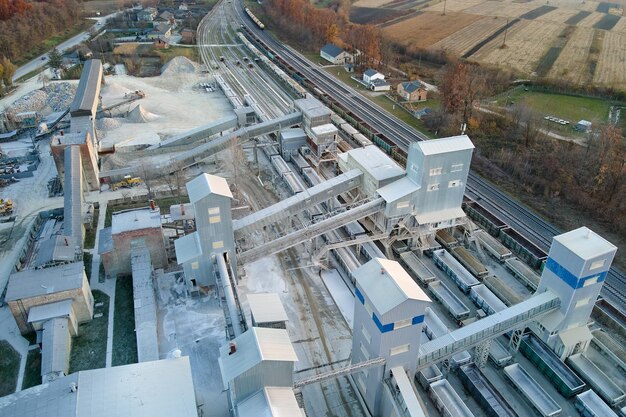 Aerial view of cargo train loaded with crushed stone materials at mining factory Railway transportation of grinded limestone ore