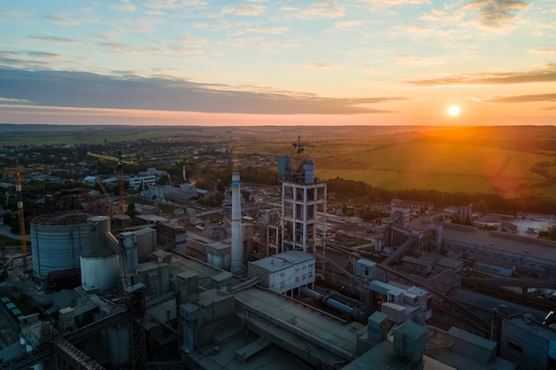 Aerial view of cement factory tower with high concrete plant structure at industrial production area. Manufacturing and global industry concept.