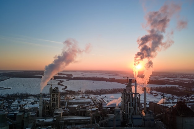 Aerial view of cement factory tower with high concrete plant structure at industrial production area at sunset Manufacturing and global industry concept