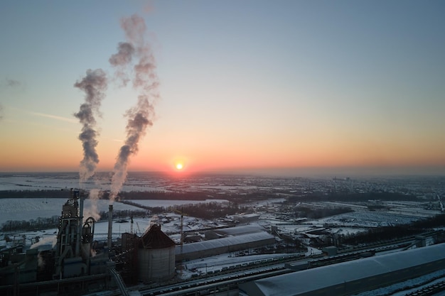 Aerial view of cement factory tower with high concrete plant structure at industrial production area at sunset Manufacturing and global industry concept