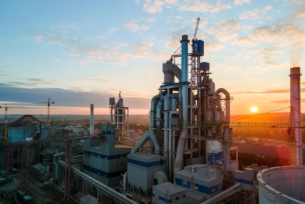 Aerial view of cement factory with high concrete plant structure and tower crane at industrial production area Manufacture and global industry concept