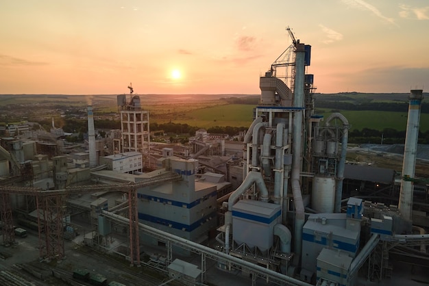 Aerial view of cement factory with high concrete plant structure and tower crane at industrial production site Manufacture and global industry concept