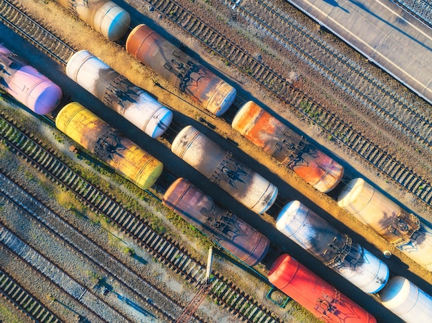 Aerial view of colorful freight trains on the railway station Cargo trains closeup Old wagons with goods on railroad Heavy industry Industrial conceptual scene with trains Top view Vintage