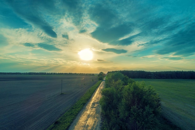 Aerial view of a country road at sunset Rural evening landscape