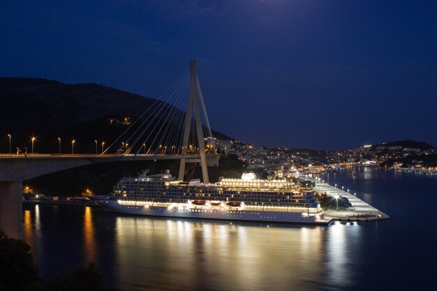 Aerial view of cruise ship at night with many lights. A harbor of Dubrovnik, beautiful night panoramic view of the Adriatic Sea.