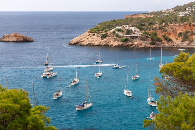 Aerial view of crystal clear turquoise water of bay Port Brut at Cala d'Hort Ibiza