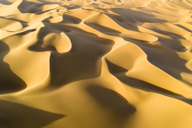 Aerial view of desert landscape in sunset golden sand dunes background texturexA