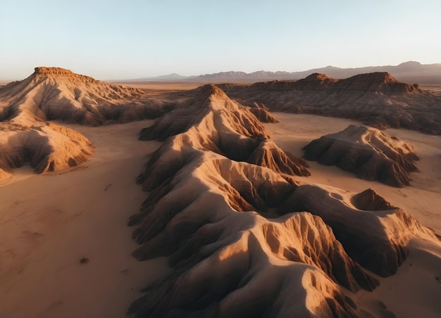 Aerial view of a desert landscape with rock formations and sand at sunset