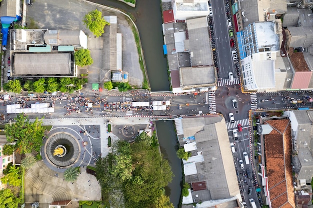 Aerial view Drone flying over phuket city ThailandDrone over a street night market in Sunday at Phuket Town and Tourists walking shopping at old street full of local vendors selling Food and Clothes