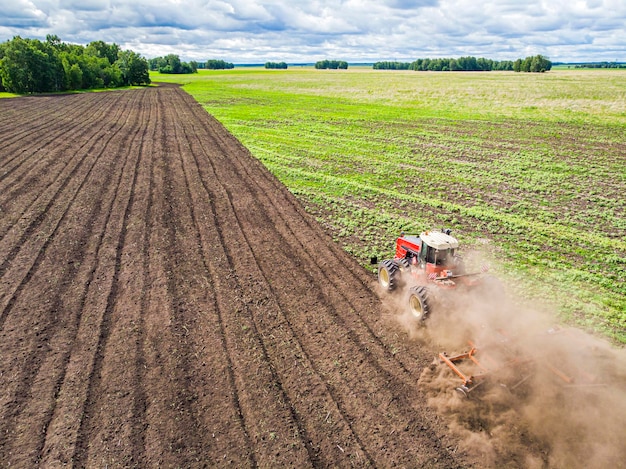 Aerial view drone of harvest field with tractor mows dry grass. Autumn yellow field with a haystack after harvest top view. Harvesting in the fields. Stock up on hay for the winter. Top view.