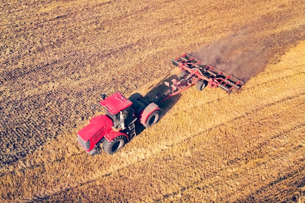 Aerial view drone of harvest field with tractor mows dry grass Autumn yellow field with a haystack after harvest top view Harvesting in the fields Stock up on hay for the winter Top view