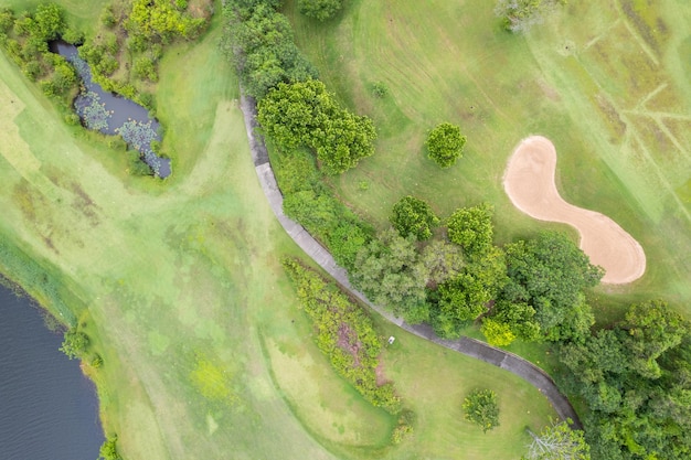 Aerial view drone shot of beautiful green golf field fairway and putting green Top down image for sport background and travel nature background Amazing view