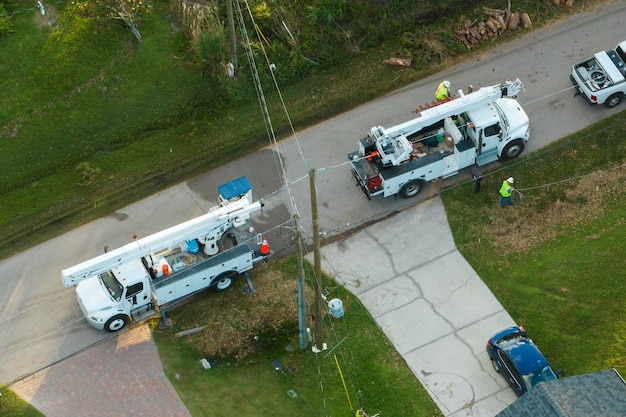 Aerial view of electrician workers repairing damaged power lines after hurricane Ian in Florida suburban area