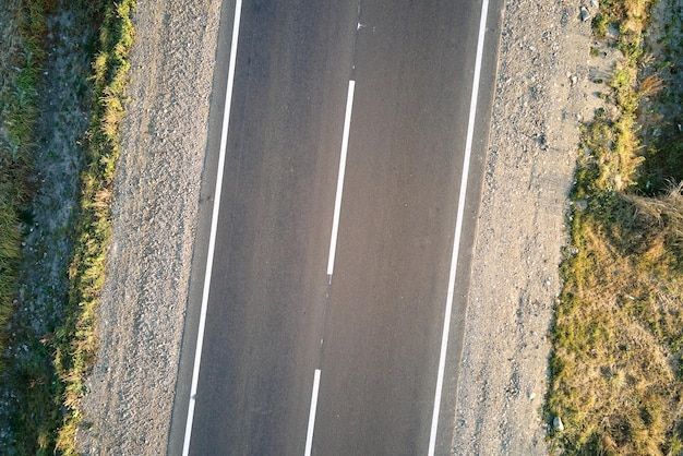 Aerial view of empty intercity road at sunset. Top view from drone of highway in evening.