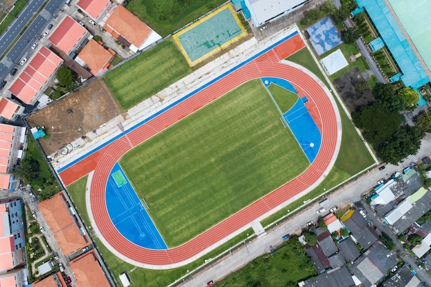 Aerial view of empty new soccer field from above with running tracks around it Amazing new small stadium for many sport disciplines at phuket thailand.