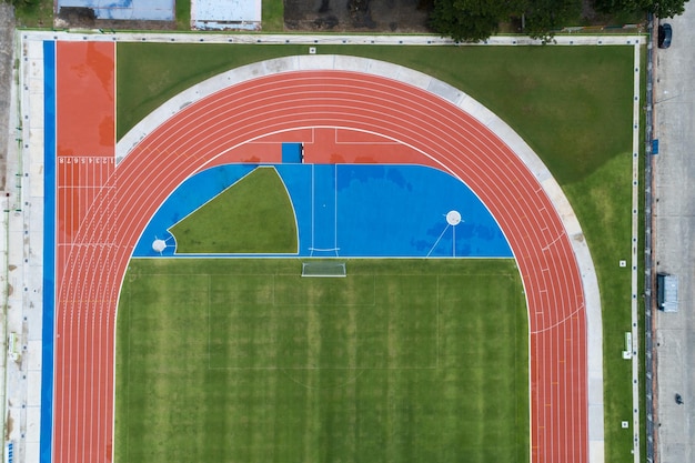 Aerial view of empty new soccer field from above with running tracks around it Amazing new small stadium for many sport disciplines at phuket thailand.