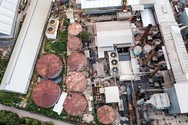 Aerial view of Ethanol industrial or biofuel refinery processing factory with smoke from chimney, storage tanks and warehouse. Problem of pollution climate and global warming