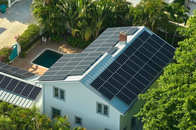 Aerial view of expensive american home roof with blue solar photovoltaic panels for producing clean ecological electric energy Investing in renewable electricity for retirement income