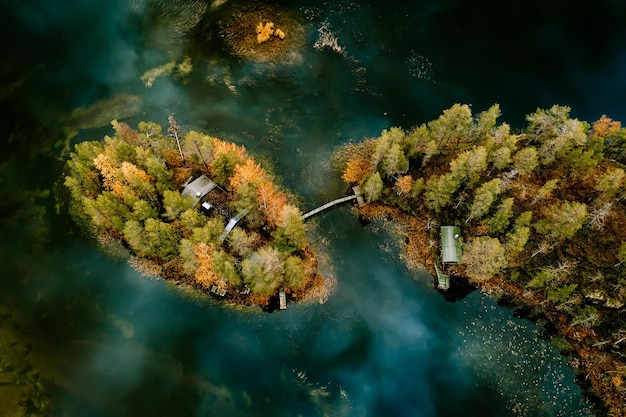 Aerial view of fall autumn colors forest and blue lake with island in rural Finland