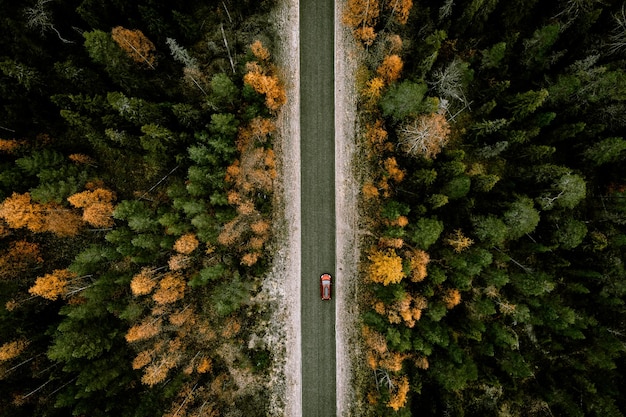 Aerial view of fall road with autumn woods and first snow in Finland