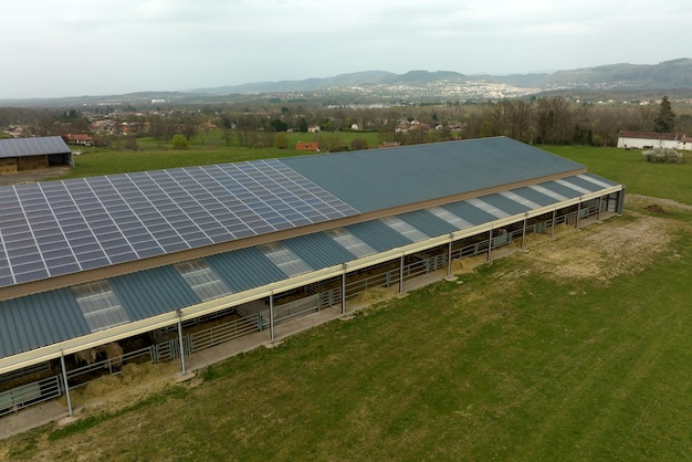 Aerial view of farm building with photovoltaic solar panels mounted on rooftop for producing clean ecological electricity Production of renewable energy concept