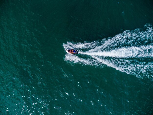 Aerial view of floating scooter on blue sea at sunny day