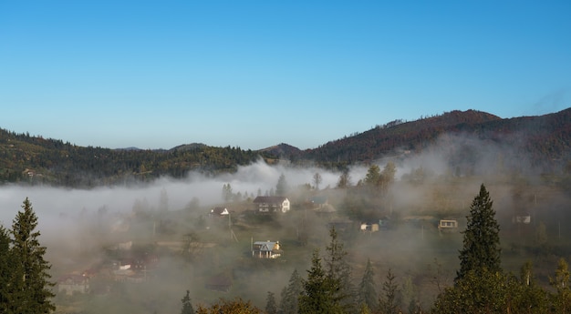 Aerial view of foggy Ukrainian village on top of mountains