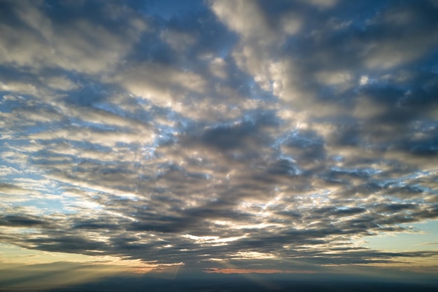 Aerial view from above at high altitude of dense puffy cumulus clouds flying in evening Amazing sunset from airplane window point of view