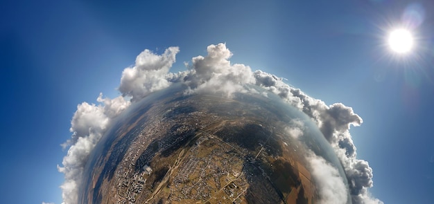 Aerial view from high altitude of little planet with distant city covered with puffy cumulus clouds flying by before rainstorm Airplane point of view of landscape in cloudy weather