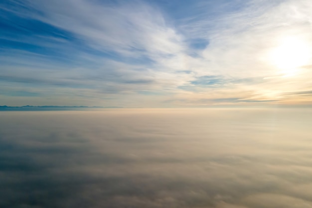 Aerial view from above of white puffy clouds in bright sunny day