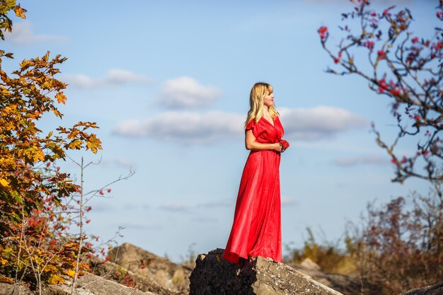 Aerial view on girl in red dress on rock or concrete ruined structure