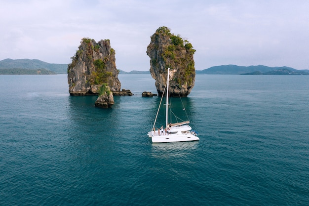 Aerial view of happy millenial friends resting on sailing yacht on sea ocean trip