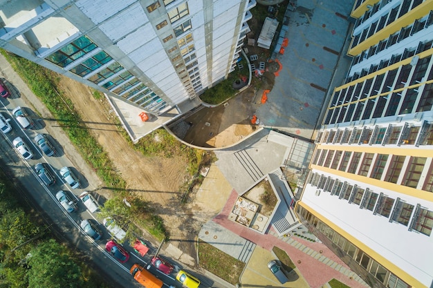 Aerial view of high residential apartment building with storey numbers on wall under construction. Real estate development.