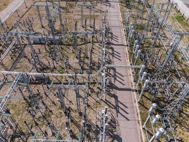 Aerial view of a high voltage electrical substation with tall pylons and cables