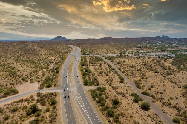 Aerial view highway across the arid desert Arizona mountains adventure traveling desert road near Fountain Hills small town residential district