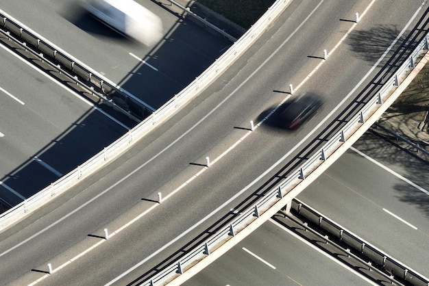 Aerial view of highway road intersection with fast moving heavy traffic Intercity transportation with many cars and trucks