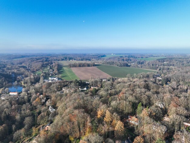 Photo aerial view of houses surrounded by forest and farmland in the country side area of walloon belgium