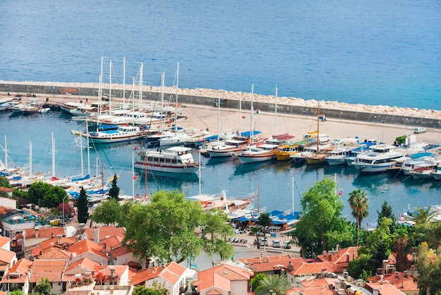 Aerial view of houses with red tile roofs and yachts at the marina