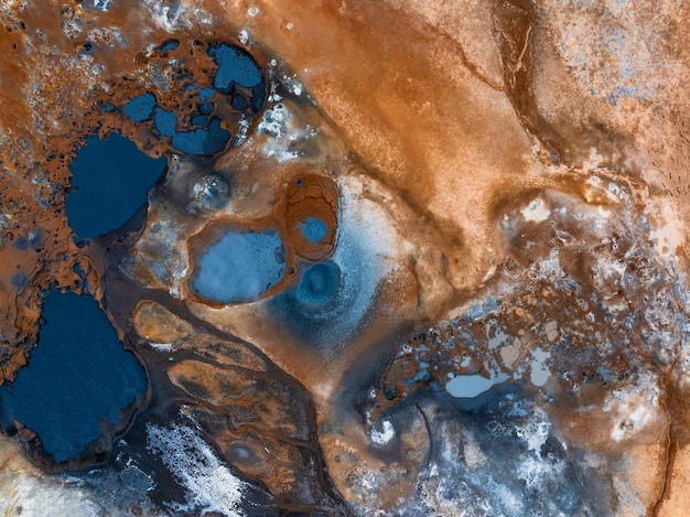 Photo aerial view of hverir geothermal area iceland showcasing vibrant blue and orange geothermal pools and mud pits in a surreal landscape