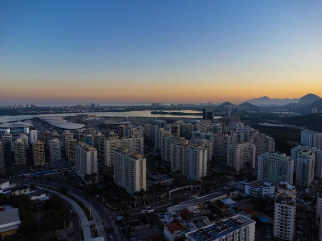 Aerial view of Jacarepagua lagoon in Rio de Janeiro Brazil Residential buildings and mountains around the lake Barra da Tijuca beach in the background Sunny day Sunset Drone photo