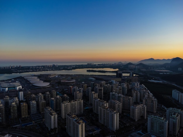 Aerial view of Jacarepagua lagoon in Rio de Janeiro Brazil Residential buildings and mountains around the lake Barra da Tijuca beach in the background Sunny day Sunset Drone photo