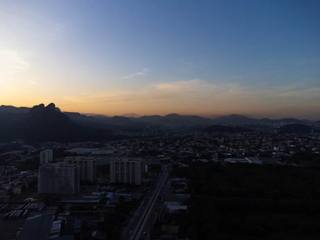 Aerial view of Jacarepagua in Rio de Janeiro Brazil Residential buildings and mountains in the background Sunny day Sunset Drone photo