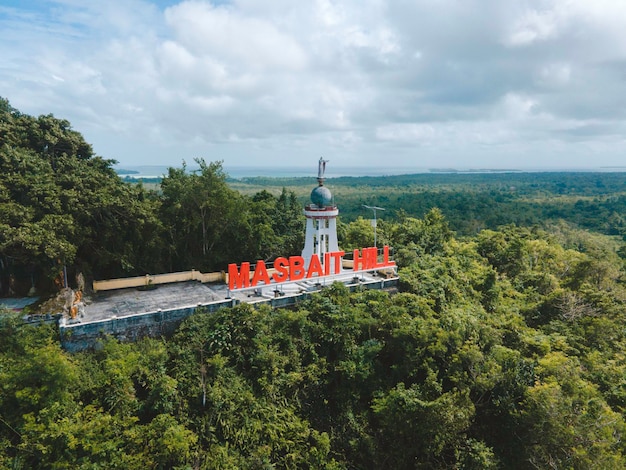 Aerial view of Jesus statue with beautiful beach view in small island. Maluku, Indonesia - July, 2022