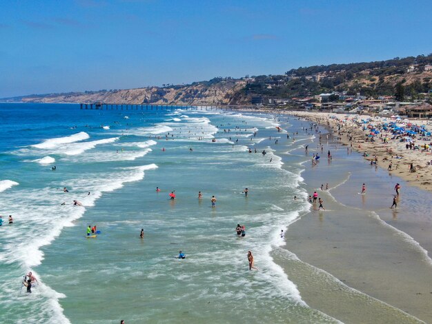 Aerial view of La Jolla bay with nice small waves and tourist enjoying the beach day