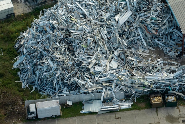 Aerial view of large pile of scrap aluminum metal from broken houses after hurricane Ian swept through Florida Recycle of broken parts of mobile homes