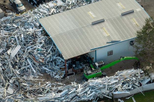 Aerial view of large pile of scrap aluminum metal from broken houses after hurricane Ian swept through Florida Recycle of broken parts of mobile homes